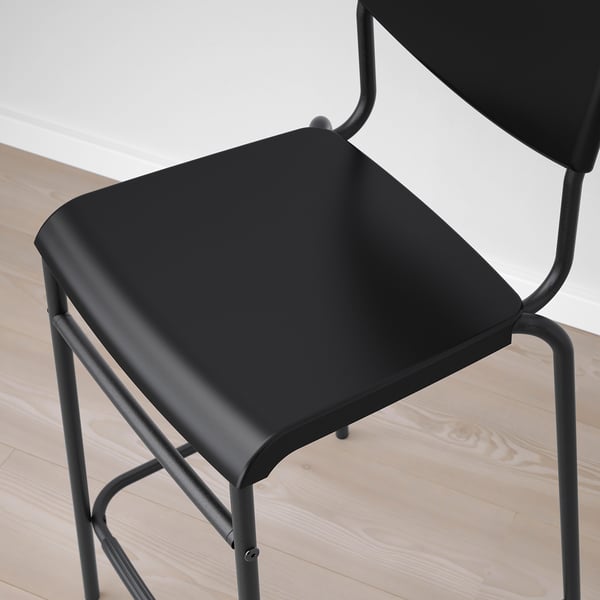 Modern black bar stool with sleek metal frame and curved seat. Ideal for counters, sturdy, stylish.