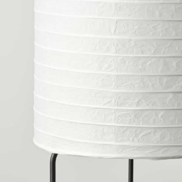 Close-up of sleek white paper floor lamp with black metal base, showcasing its minimalist design and quality craftsmanship.