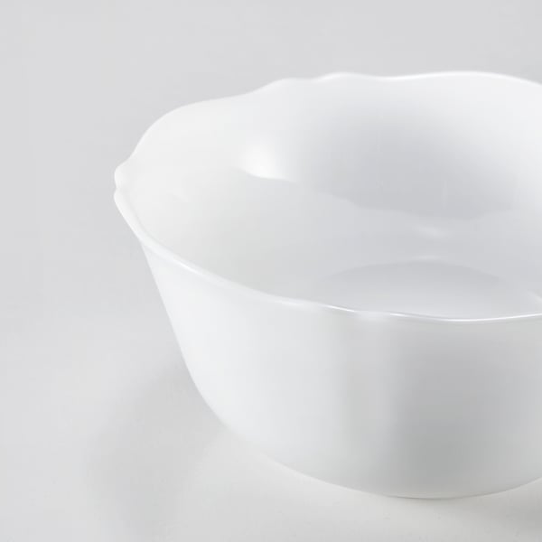 Elegant white glass bowl with wavy edges, smooth and durable, perfect for dining.
