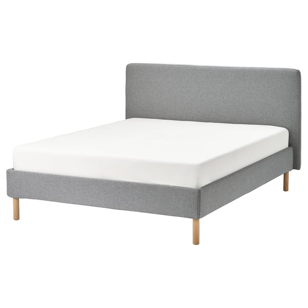 A modern grey bed with a removable fabric cover, wooden legs, and a soft headboard.
