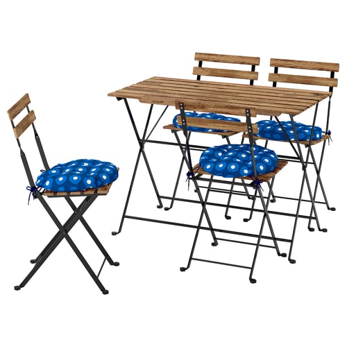 Wooden outdoor table with 4 folding chairs. Blue dotted cushions. Perfect for patio dining.