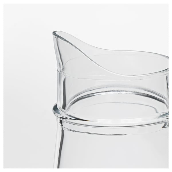 Translucent glass jug with sturdy handle, smooth curves, and wide opening. Ideal for beverages or decorative use.