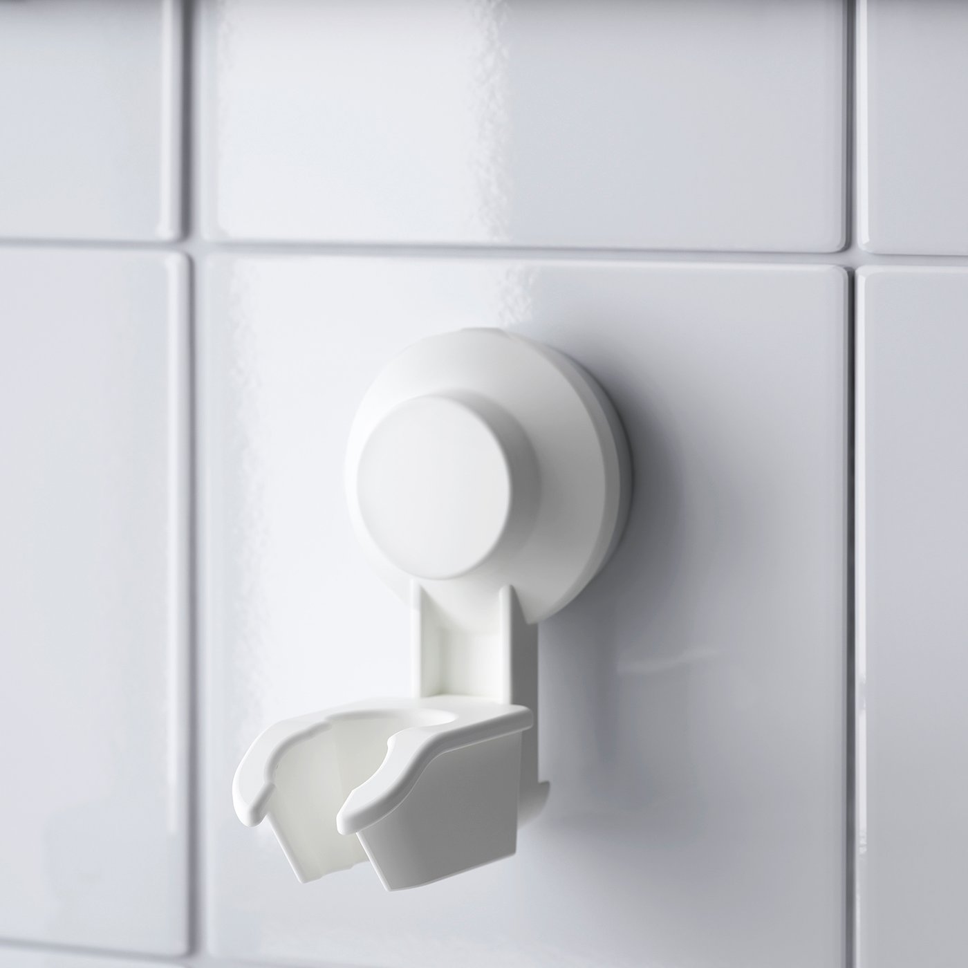 White suction cup wall mount, securely attached to a tiled surface, designed to hold bathroom accessories.
