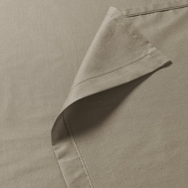 Close-up of high-quality, smooth beige fabric showing tight, even stitching and crisp texture, highlighting durability and fine craftsmanship.