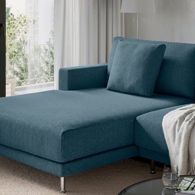 Turquoise sectional sofa with clean lines and large cushions near a window.