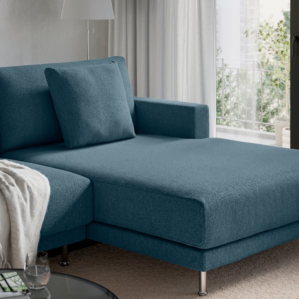 Blue sectional sofa, UPPÅKRA, with chaise, oversized cushions, near window with view.