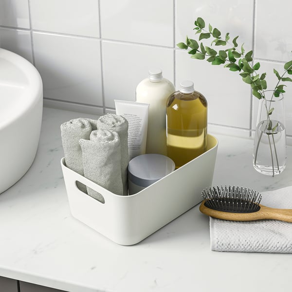 Bathroom organiser with towels, bottles, and brush, featuring handles for portability and easy access.