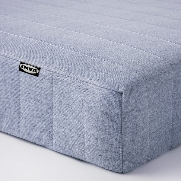 A grey IKEA mattress shown from the side. Soft fabric cover, firm and supportive design.