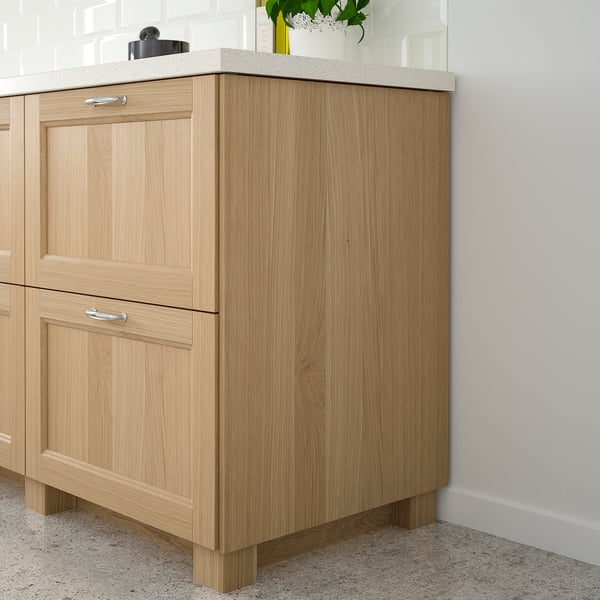 Light wooden kitchen cabinets with light countertops, simple handles, and a natural finish against a white wall, slightly larger than a potted plant.