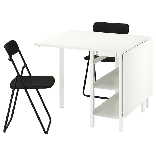 White VIHALS foldable table and black chairs. Modern, space-saving design. Table has adjustable shelves.