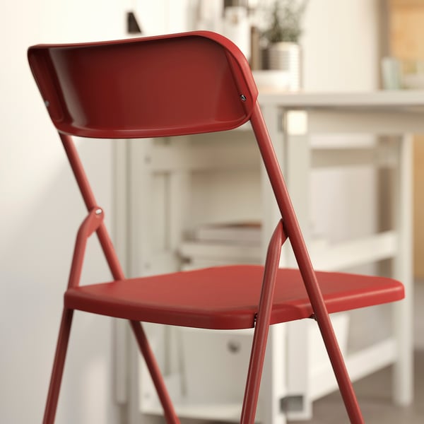 Red foldable chair with modern design, ideal for compact spaces. Easy to wipe and carry.