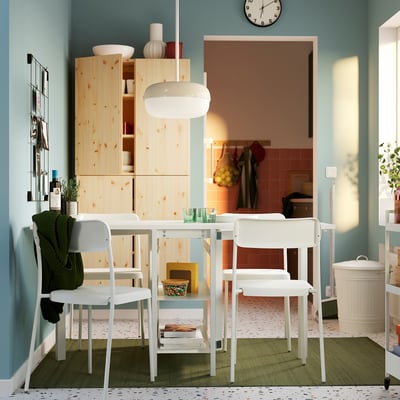Bright room with drinks and books on VIHALS table by kitchen.