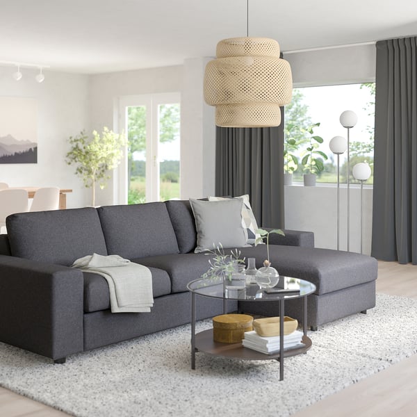 Modern living room with VIMLE sofa, pendant lamp, glass coffee table, and plants.