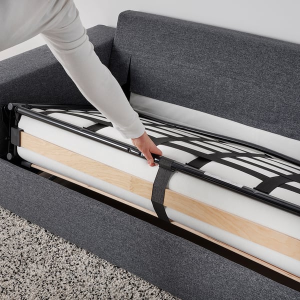 Person extends sofa-bed mechanism, transforming VIMLE sofa into a bed.