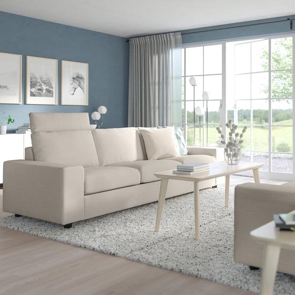 Modern living room with VIMLE sofa, blue walls, large windows, wooden table, grey rug, and floor lamp.