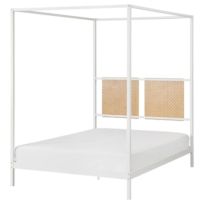 The VITARNA white metal four-poster bed in a minimalist design with cane-style headboard and footboard panels, featuring a white mattress.