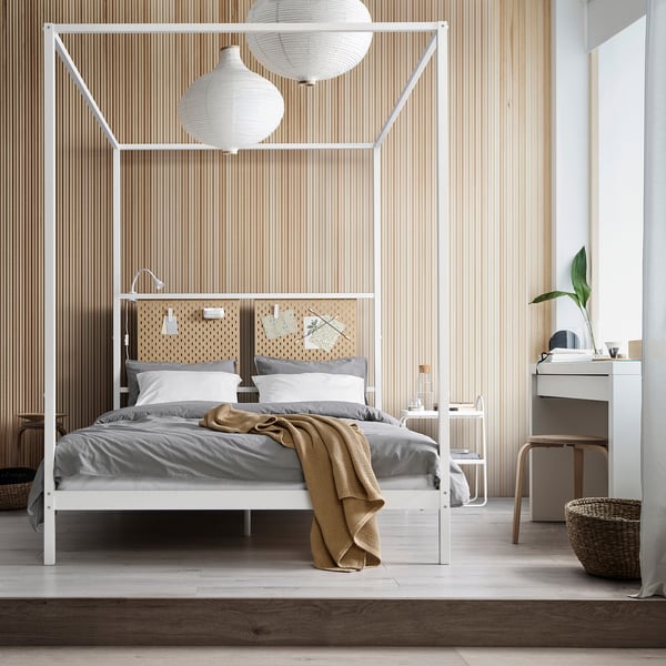 VITARNA white four-poster bed, sleek & modern, fits neatly in room, grey linens, wooden accents, soft lighting, small plant.