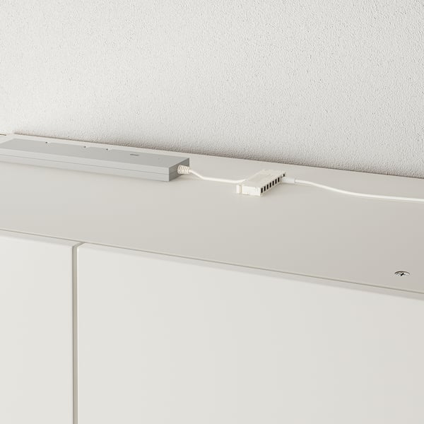 White cabinet light, adjustable neck, plugged in, mounted on white cabinet.