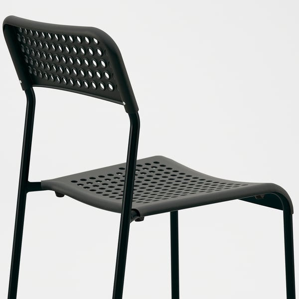 Black modern stackable chair, perforated seat and backrest, sturdy metal frame.