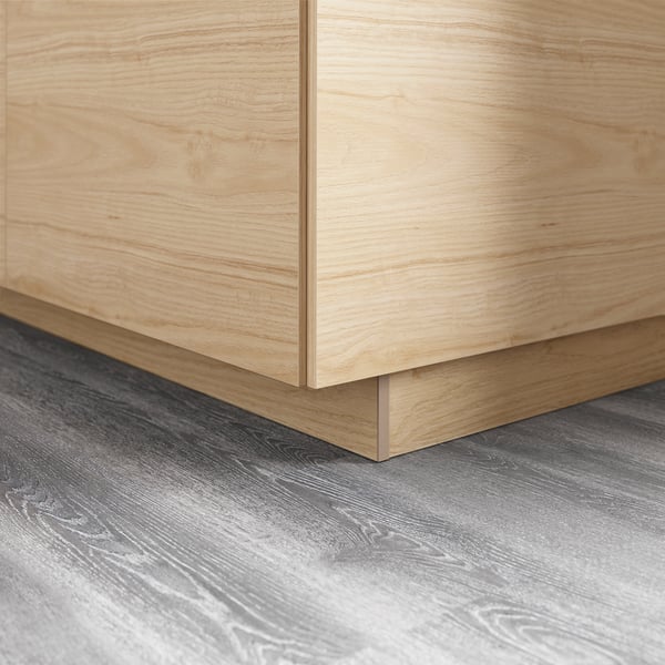 Wooden kitchen cabinets with smooth, easy-clean finish. They meet grey wood-patterned floor, creating modern look.