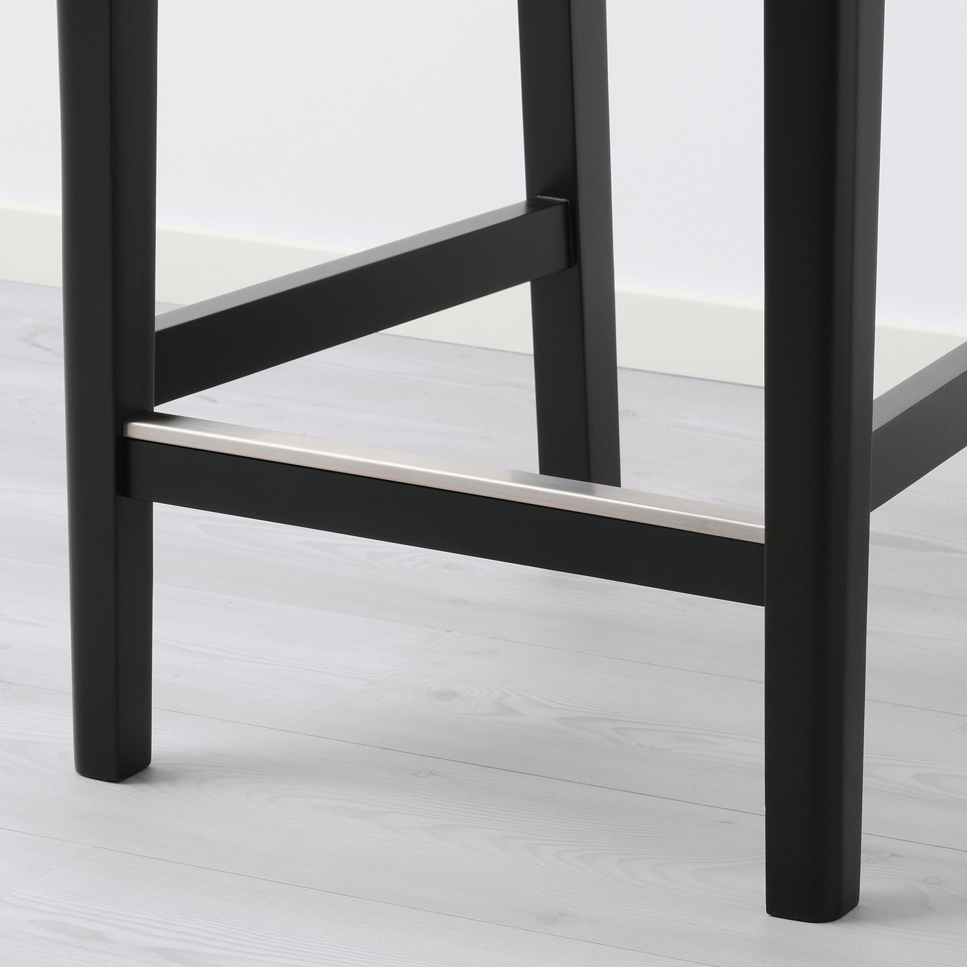 Black metal barstool with sleek design, angled backrest, and sturdy legs.