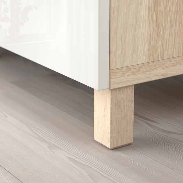 White and wood sideboard with sturdy legs on a wooden floor.