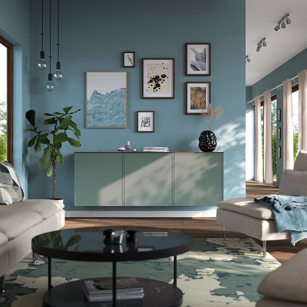 Teal BESTÅ sideboard in modern living room with blue walls, plants, and artwork.