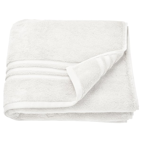 Elegant white organic cotton towels neatly stacked. Soft, absorbent with a textured border. Ideal for bathroom use.
