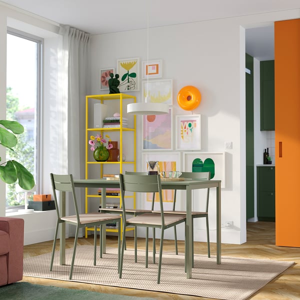 Modern dining area with BUSLÄTT chairs, rectangular table, bright art, and yellow shelving.