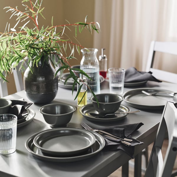 Grey DAGGASTER dinnerware on table, earthy speckled stoneware.