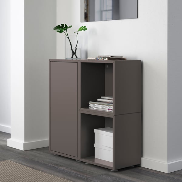 Modern storage unit with compartments, books, plants, and filing cabinet.
