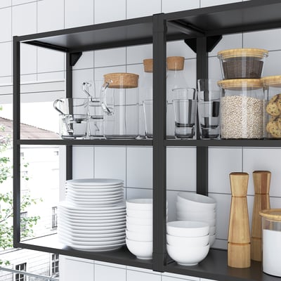 Black metal kitchen shelves hold glass jars, white bowls, and dishes.