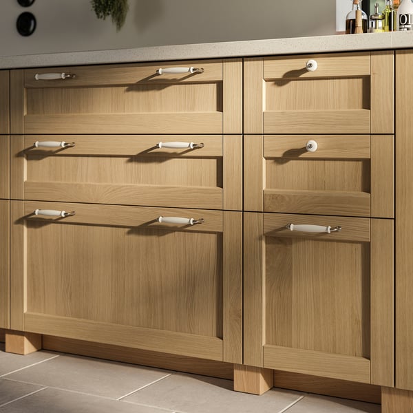 Warm wooden FORSBACKA cabinets with white handles and oak legs. Modern kitchen design with natural, sturdy feel.
