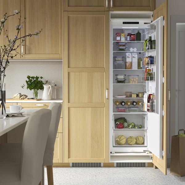 Modern kitchen with open integrated fridge displaying various foods, adjustable tempered glass shelves, led lighting, and touch control panel.