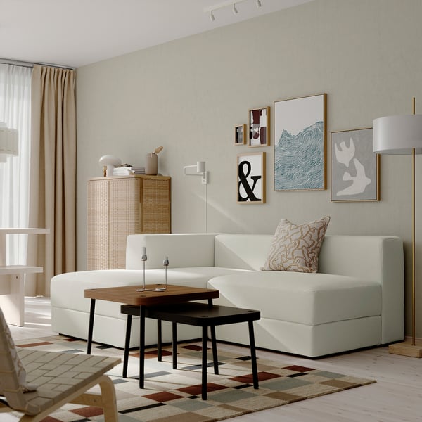 Modern living room with JÄTTEBO modular sofa in white. Includes chaise & 1. 5-seat module, wooden coffee table, rug, & wall art.