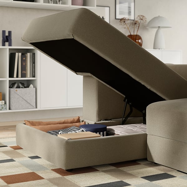 Beige JÄTTEBO sofa with lift-up seat revealing storage; perfect for additional guest sleep space.