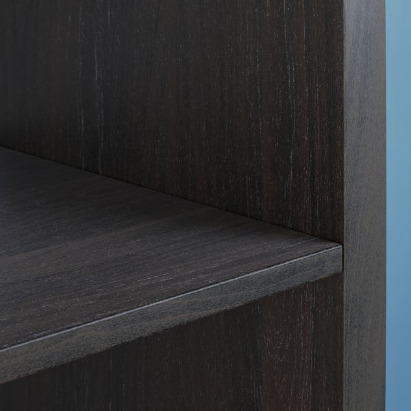 Black wooden shelf unit close-up. Vertical sections with smooth, dark finish. Square edges and clean design.