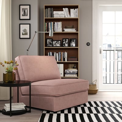 Pink KIVIK sofa-bed in cosy living area with bookshelf and rug. Alternatively, pink KIVIK sofa-bed in small living space with bookshelf and rug.