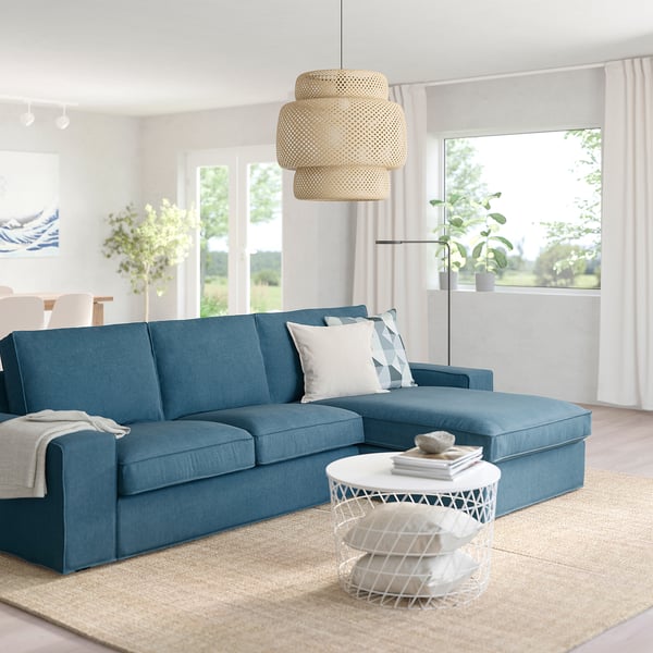 Modern living room with KIVIK sofa, pendant light, and side table. Bright with large windows.