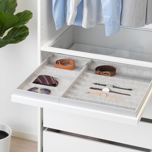 White wardrobe drawer organiser with compartments for accessories: belts, ties, and watch.