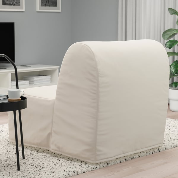 A modern, white LYCKSELE LÖVÅS chair-bed in a living space, transforming from a chair to a single bed. It a smooth, neutral fabric cover.