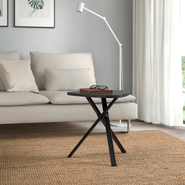 Modern living room with white sofa, MARIEDAMM small side table in black, rectangular top, criss-cross legs, near window.