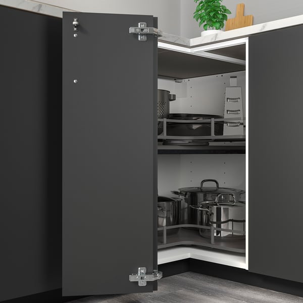 Grey kitchen cabinet, partially open with pots, adjustable hinges.