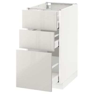 White modern kitchen cabinet with three open drawers; sleek, glossy finish.