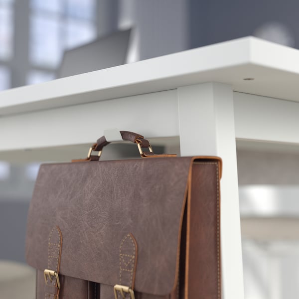 Brown leather bag hook on white high table edge.