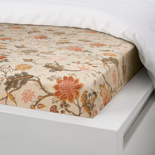 Beige floral bed cover with fitted elastic on white bed, showcasing comfy, breathable fabric.