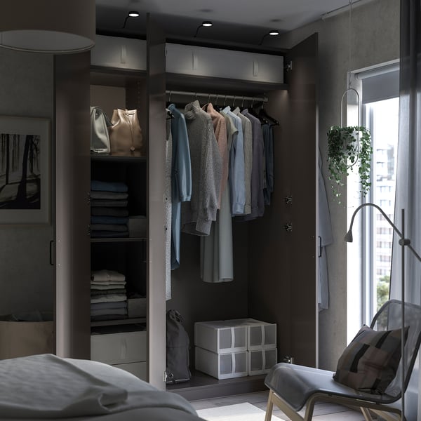 Modern bedroom with PAX wardrobe, grey shelves, chair, and plant.