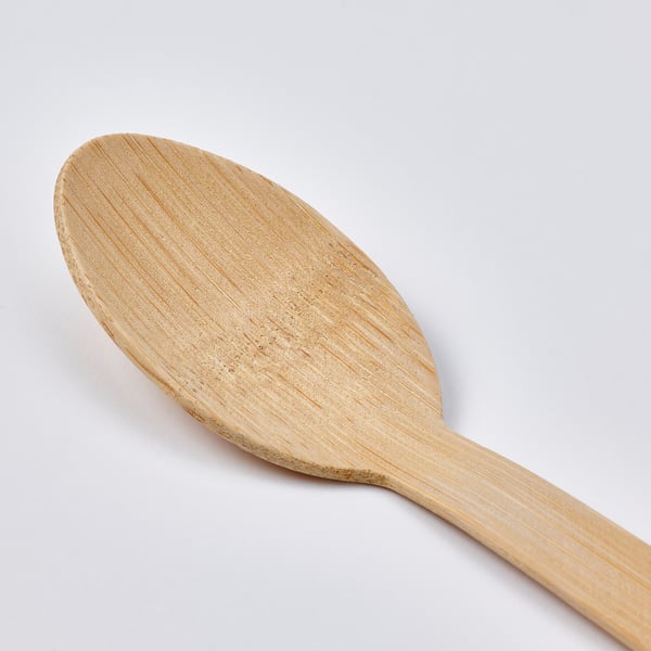 Close-up of a well-crafted bamboo spoon on a plain background, displays smooth texture and natural grain.