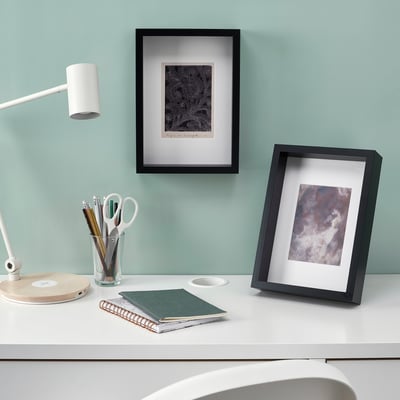 Desk with art frames, lamp, and stationery. Frames can stand or hang, with acid-free mounts.