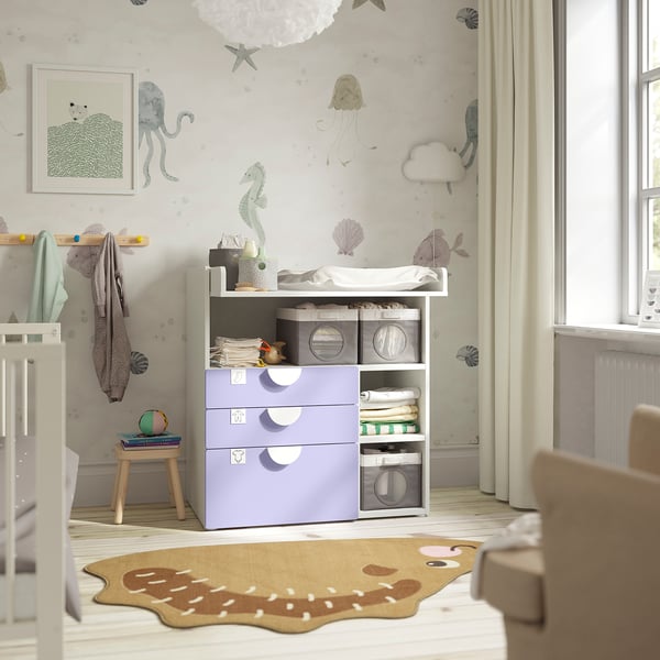 SMÅSTAD changing table in light purple with storage, ocean-themed wallpaper, and nearby crib.